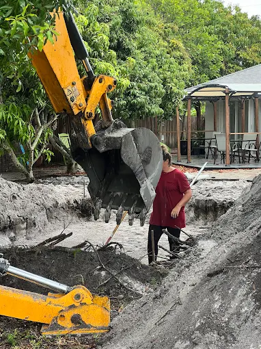 A man is digging a hole in the ground with a bulldozer.