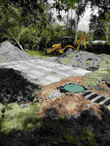 A yellow bulldozer is digging a hole in the ground.