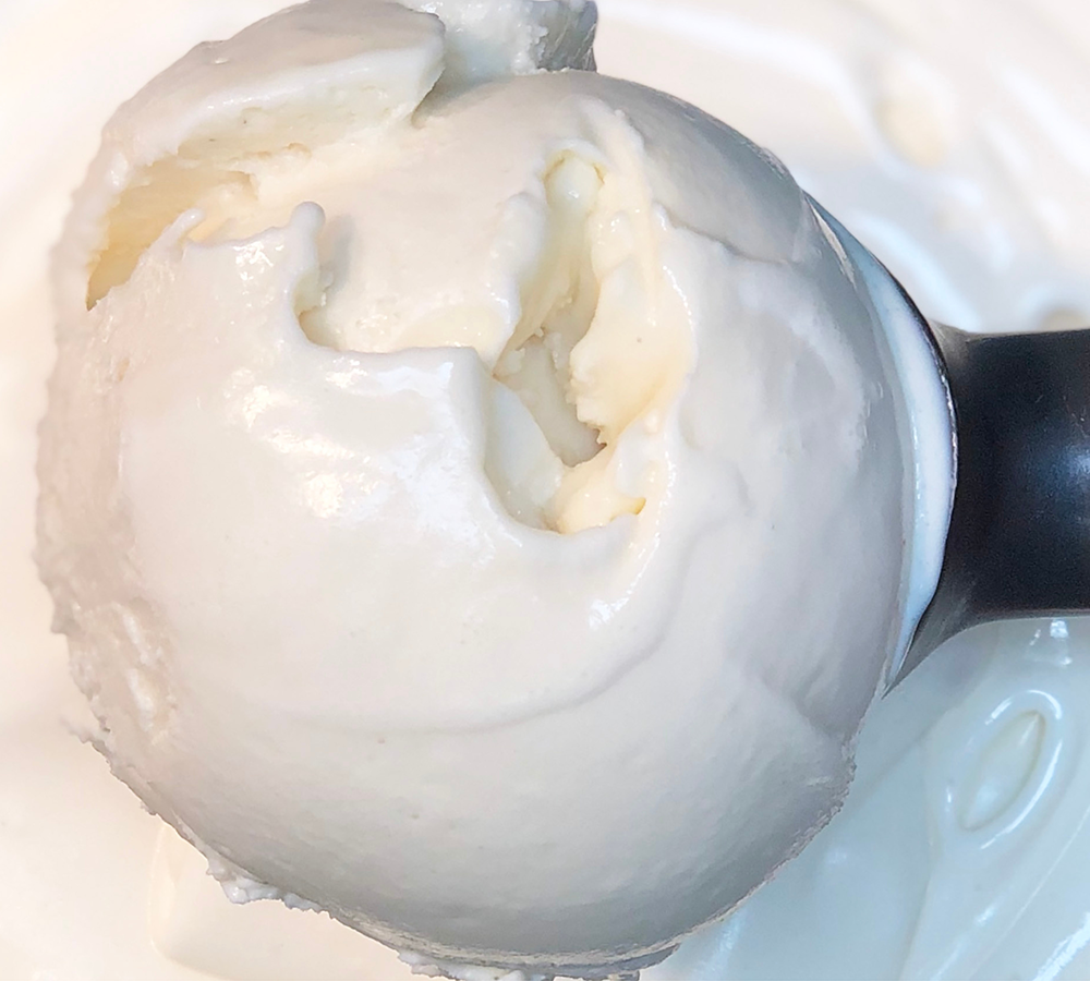 A close up of a scoop of ice cream on a plate.
