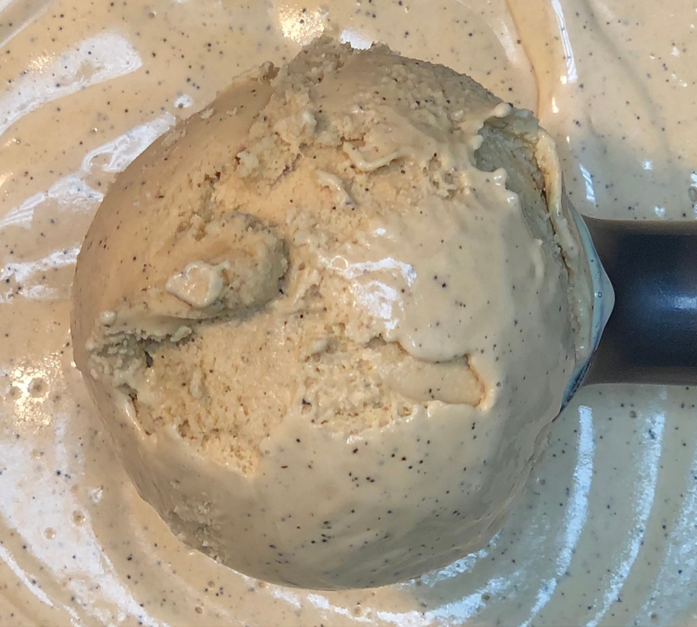 A close up of a scoop of ice cream on a plate.