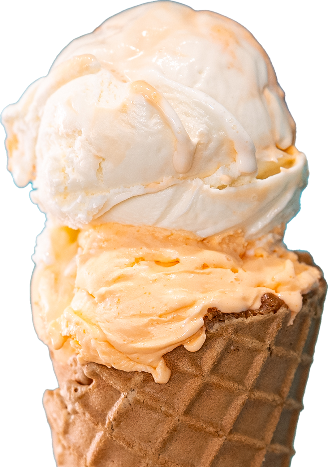 Two scoops of orange and white ice cream are stacked on top of each other