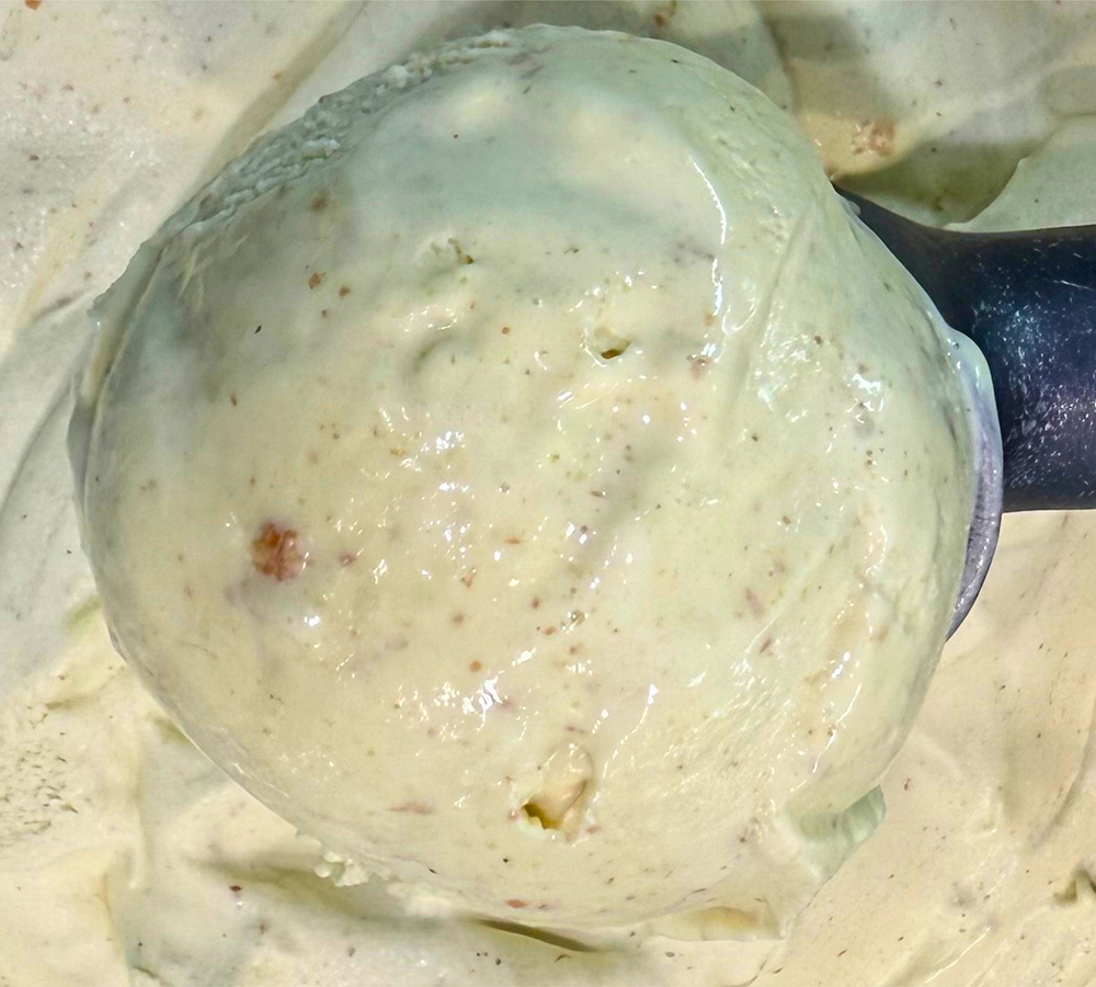 Two scoops of ice cream are in a waffle cone.