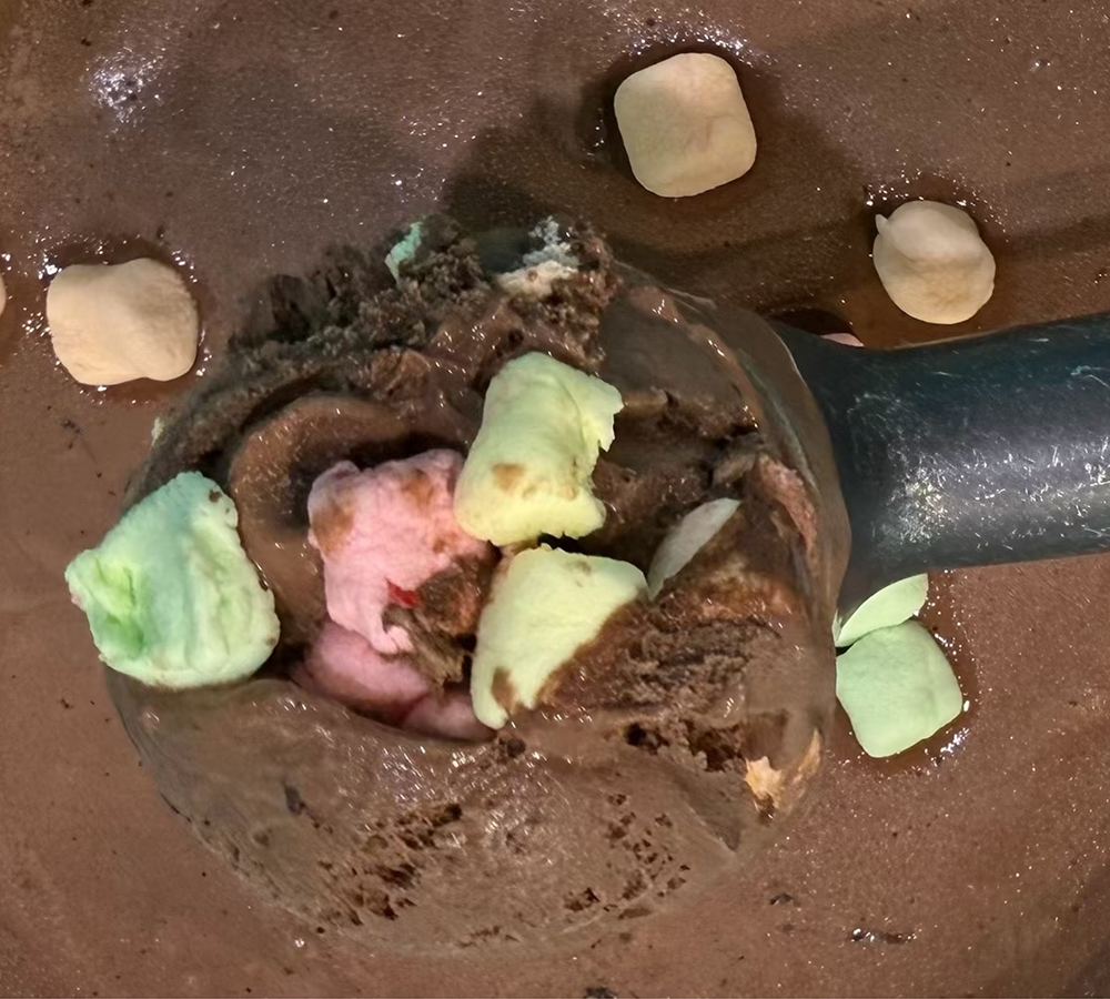 A close up of a scoop of ice cream on a white plate