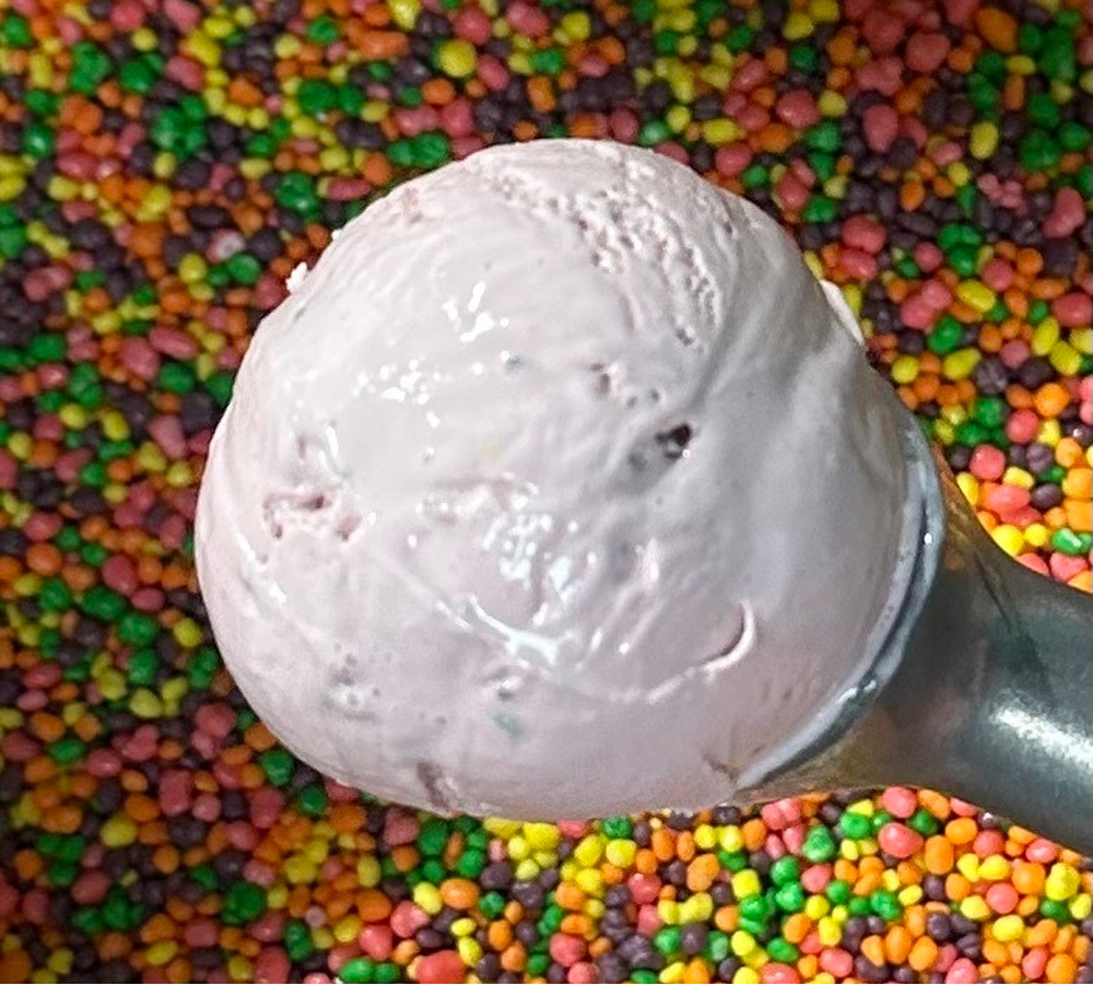 A close up of a scoop of ice cream on a white plate