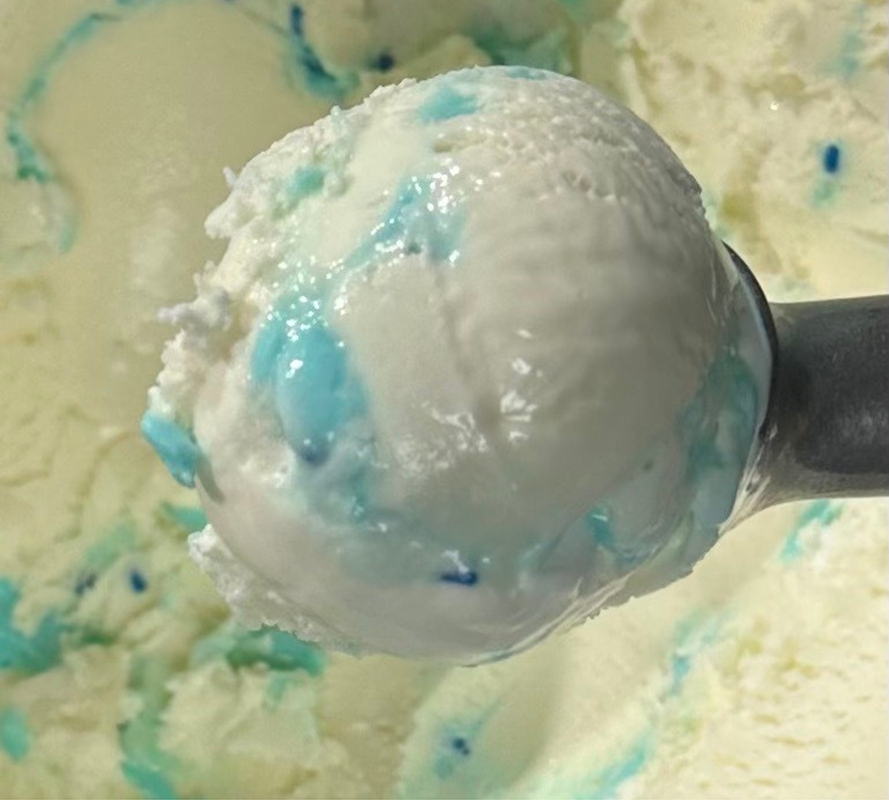 A close up of a scoop of ice cream on a white plate