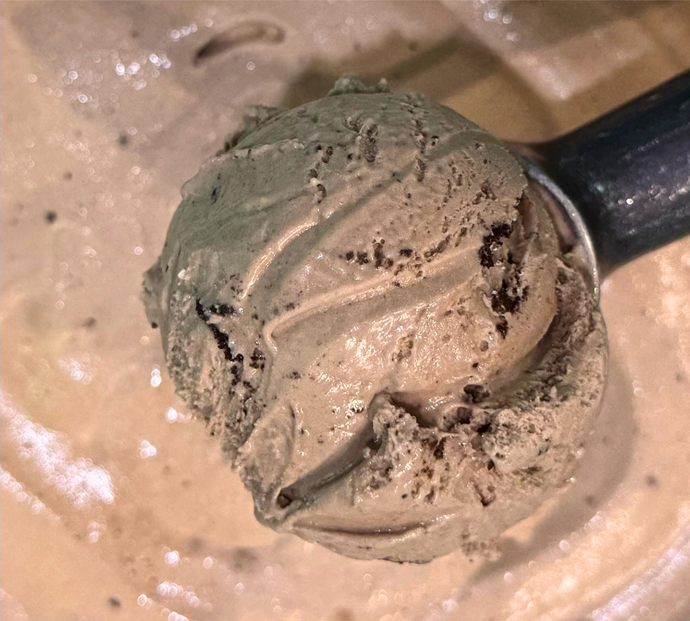 A close up of a scoop of ice cream on a white plate