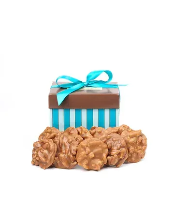A blue and white striped box filled with chocolate covered peanuts.