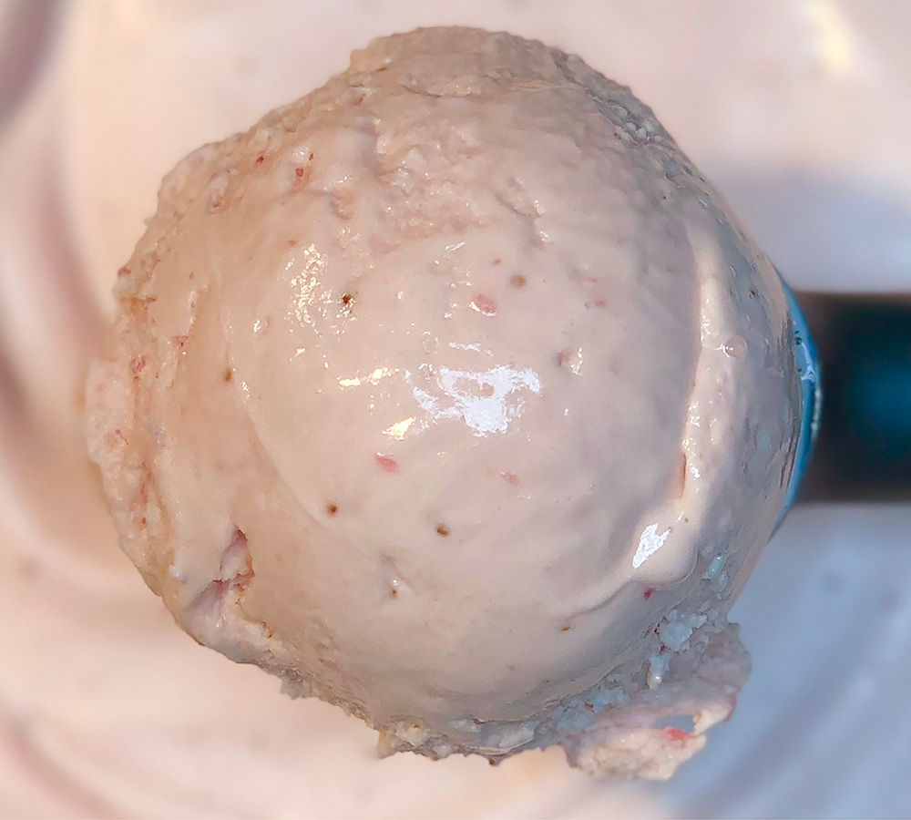 A person is holding an ice cream cone in a store