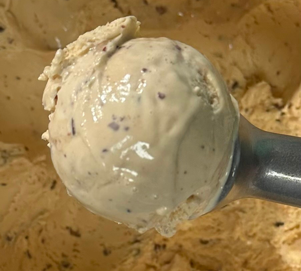 A person is holding an ice cream cone in a store