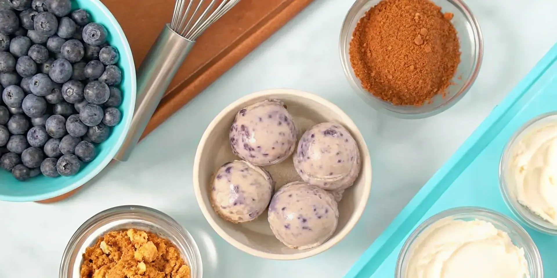 Homemade blueberry lavender ice cream in a bowl with fresh blueberries.