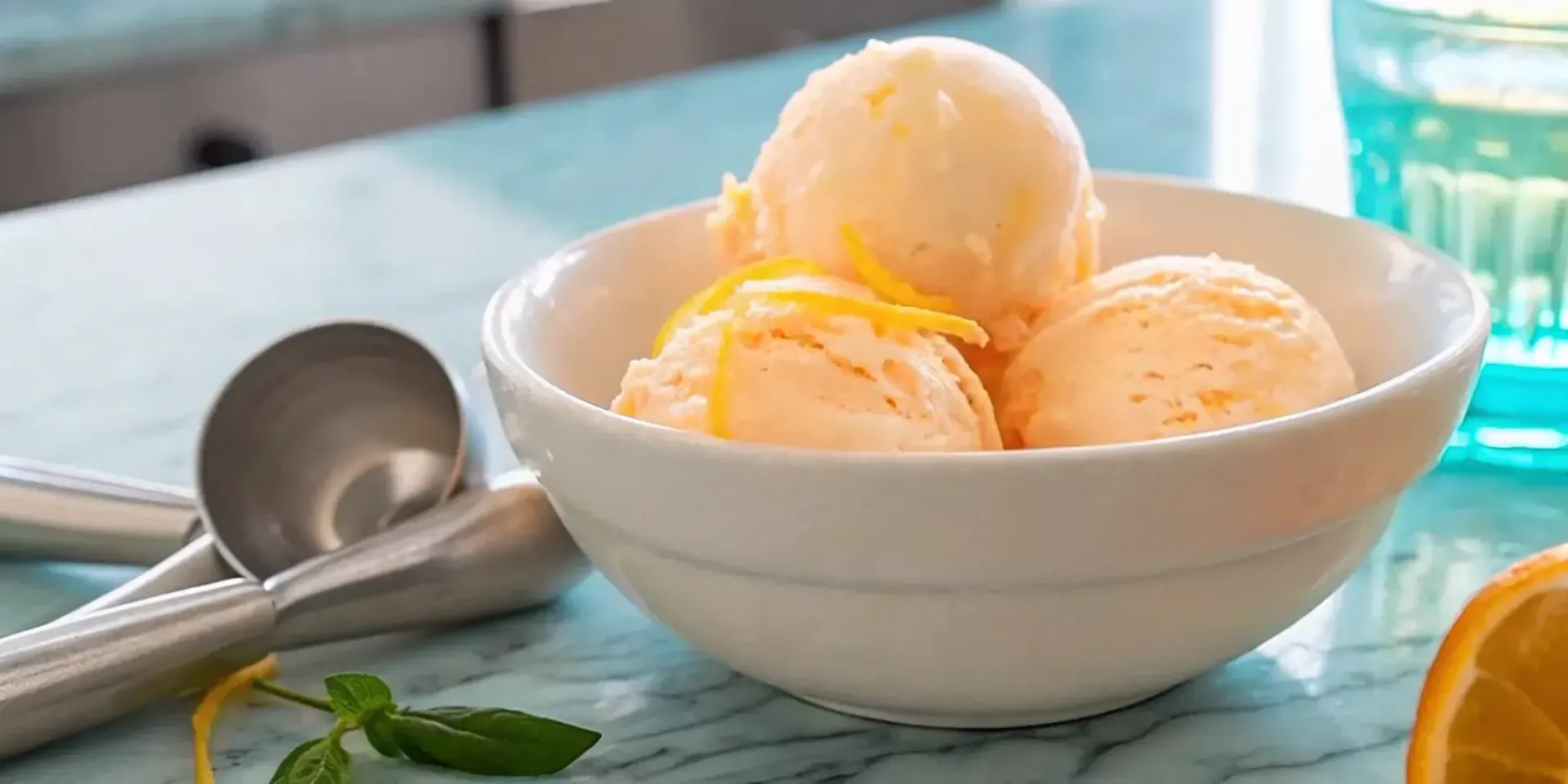 Scoops of creamy limoncello ice cream in a bowl with fresh lemon zest.