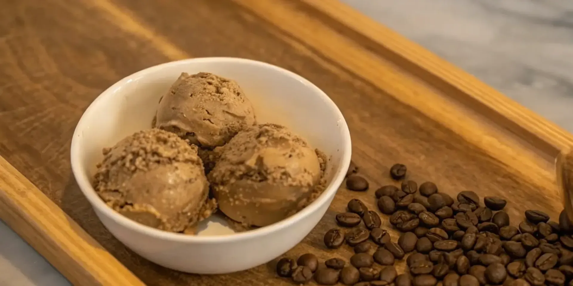 Homemade Kahlua espresso ice cream in a bowl with coffee beans.