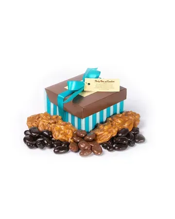 A box of chocolate covered nuts is sitting on top of a pile of chocolate covered nuts.