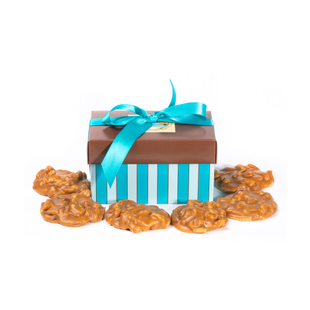 A blue and white striped box filled with pecans and a blue ribbon.
