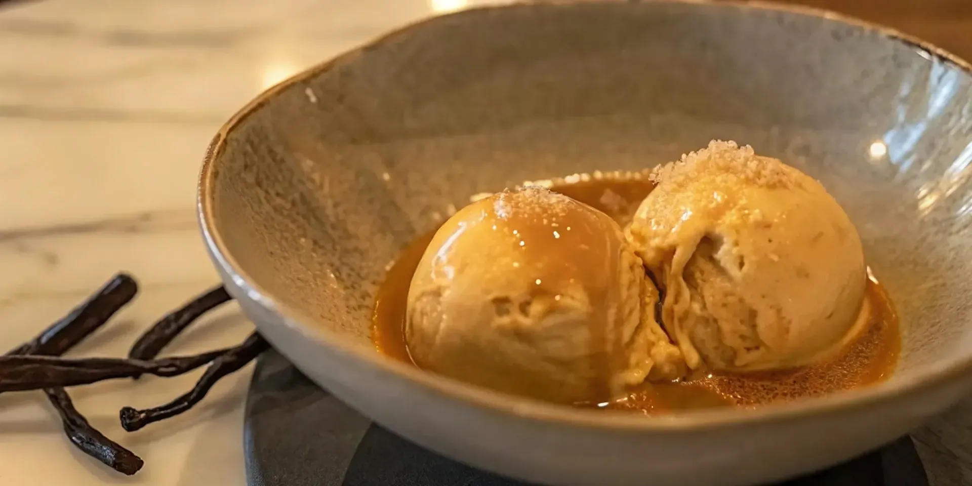 Creamy scoops of Grand Marnier ice cream in a bowl with caramel sauce.