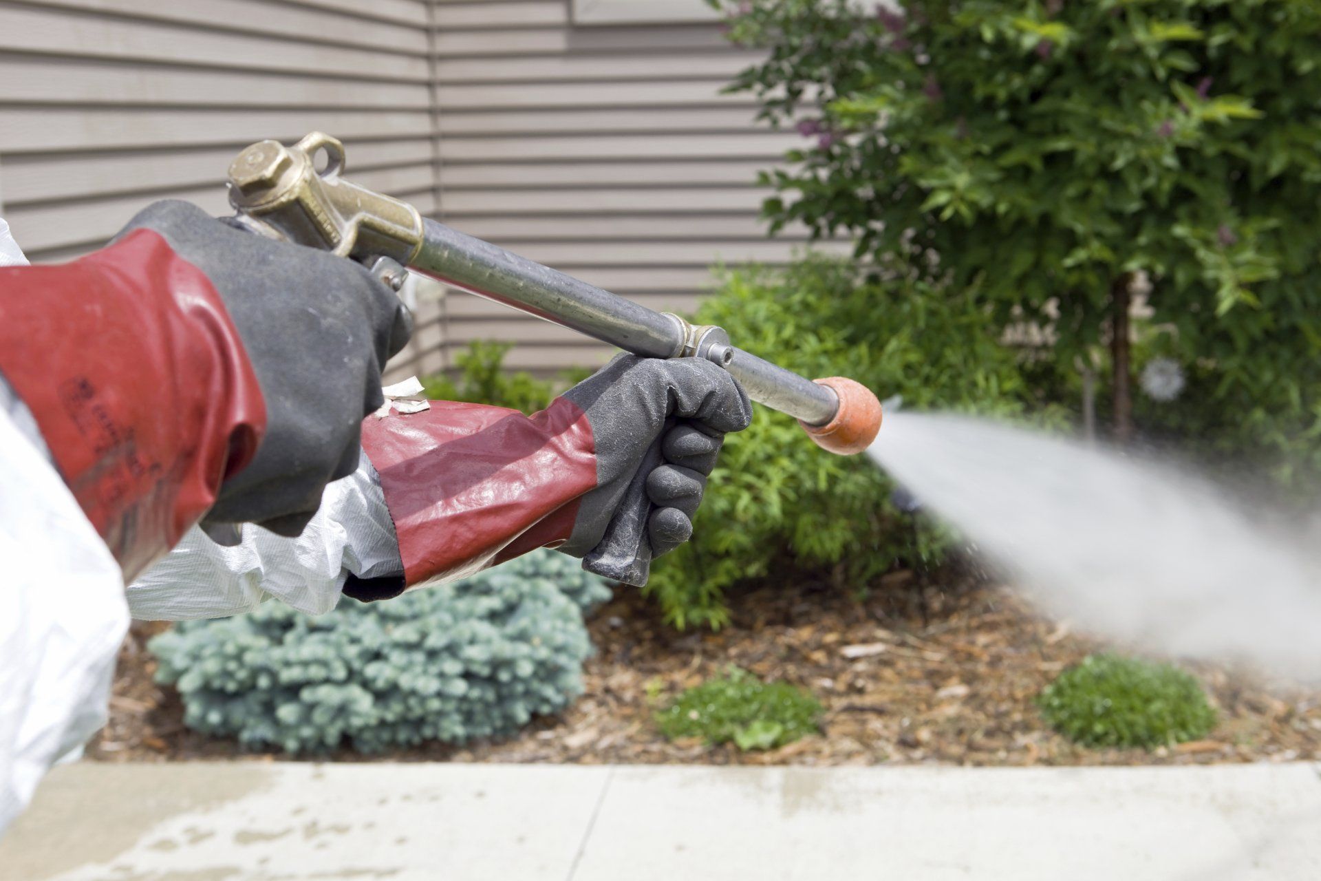 Residential Power Spray — Man Holding A Pesticide Sprayer in Oak Hill, OH Residential Power Spray — Man Holding A Pesticide Sprayer in Oak Hill, OH