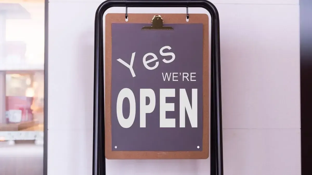 A sign that says `` yes we 're open '' is hanging on a wall.