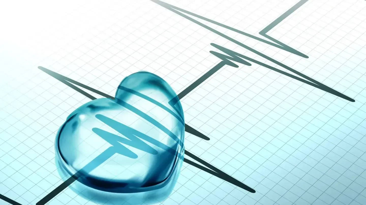 A blue heart is sitting on top of a heartbeat graph.