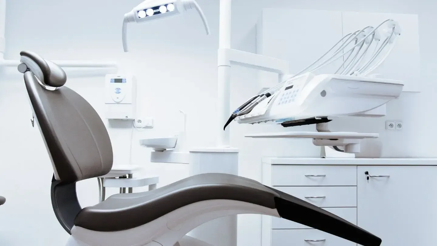 A dental chair is sitting in a dental office.