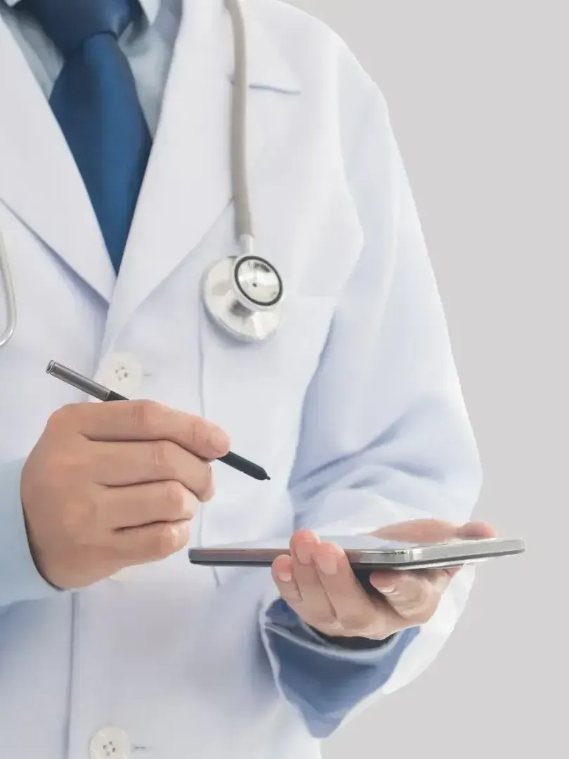 A doctor with a stethoscope around his neck is writing on a clipboard