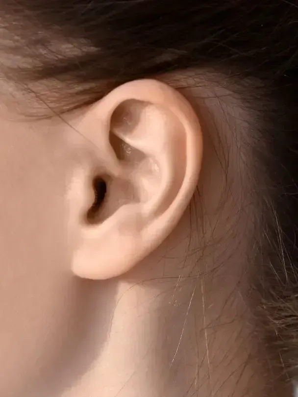 A close up of a woman 's ear with long hair.