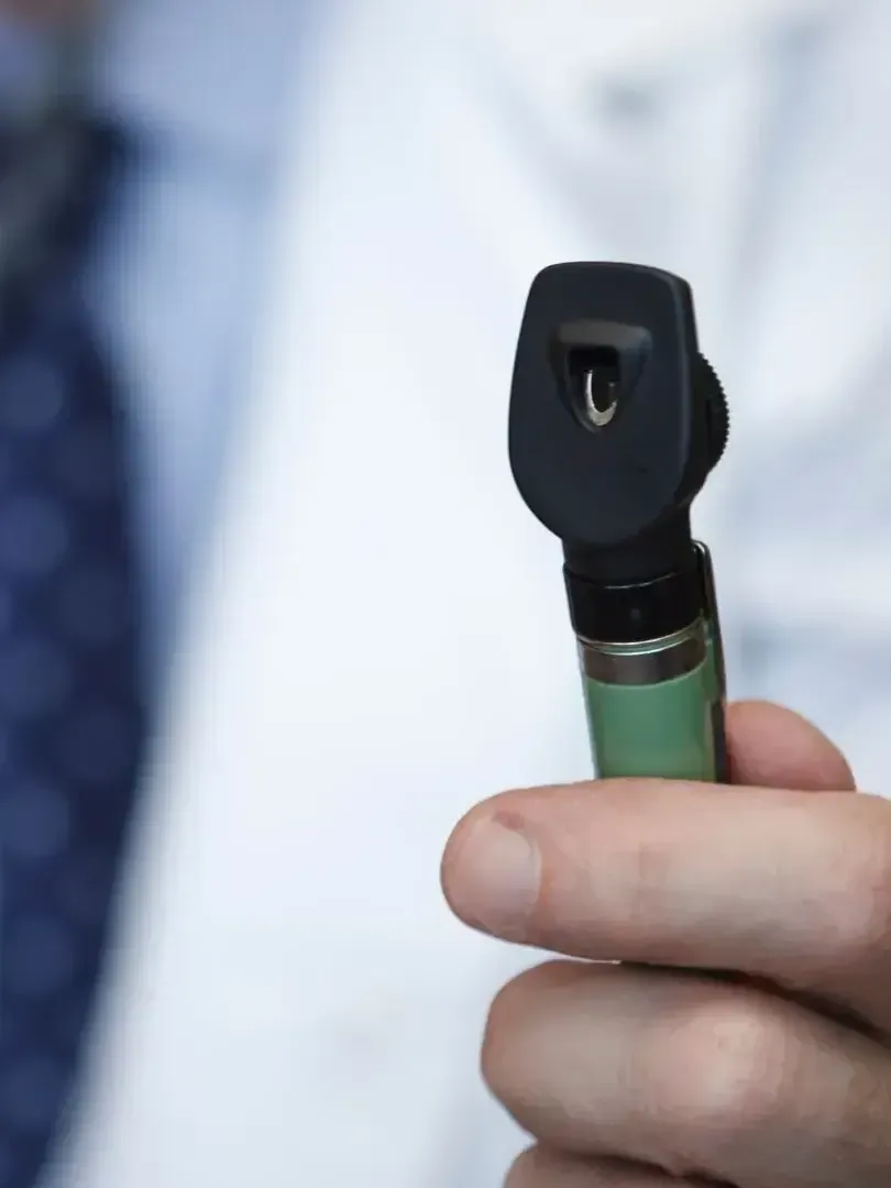 A close up of a person holding a device with the letter l on it