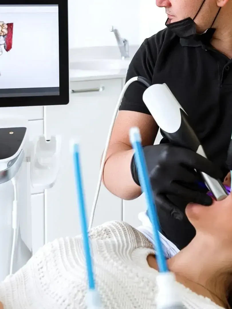 A dentist is using a machine to take a picture of a patient 's teeth
