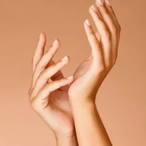 Two hands, palms up, fingers gently curved, against a peach background.