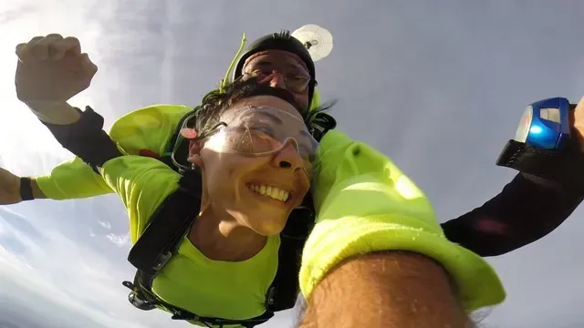 smiling tandem student in freefall in kansas city at our dropzone during a summer day