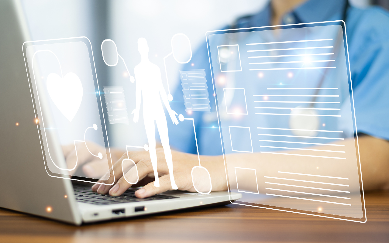 A doctor is using a laptop computer with a futuristic screen.