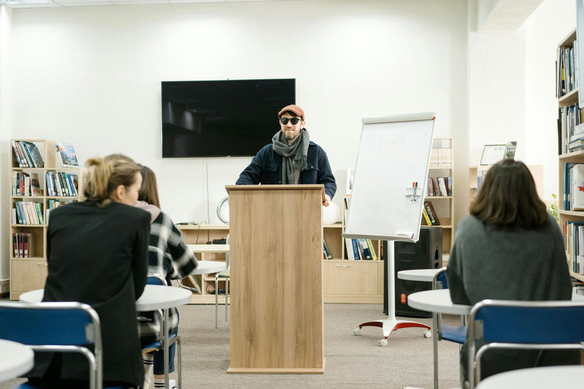 A man is standing at a podium in front of a group of people.