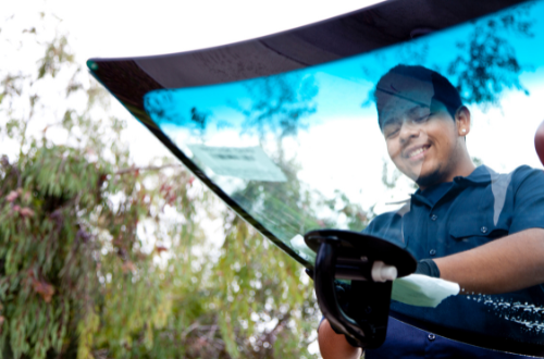 A man is installing a windshield on a car.