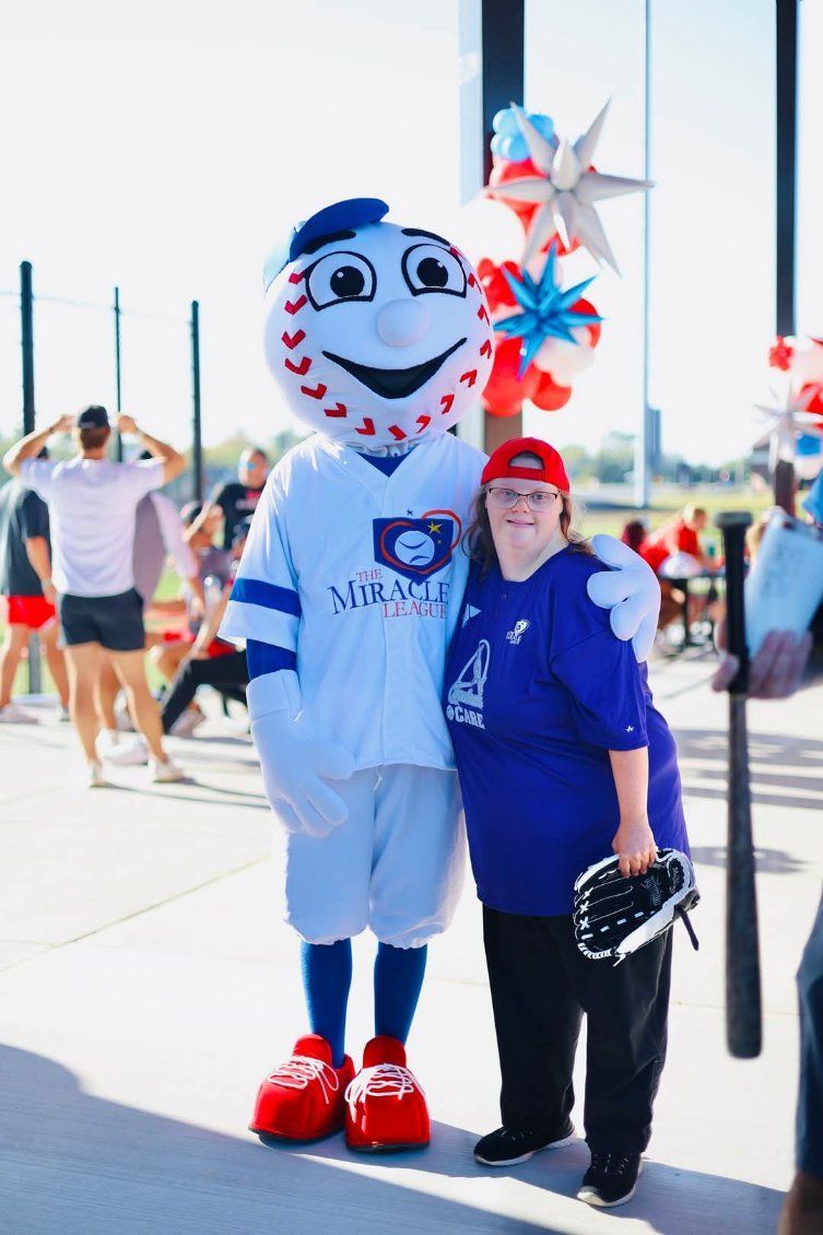 A woman is posing for a picture with a mascot