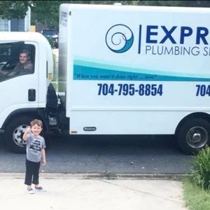 Young child giving a thumbs up in front of a Express Plumbing Services truck. Driver in the truck.