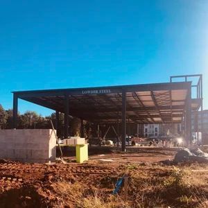 Construction site with a steel frame structure under a blue sky. 
