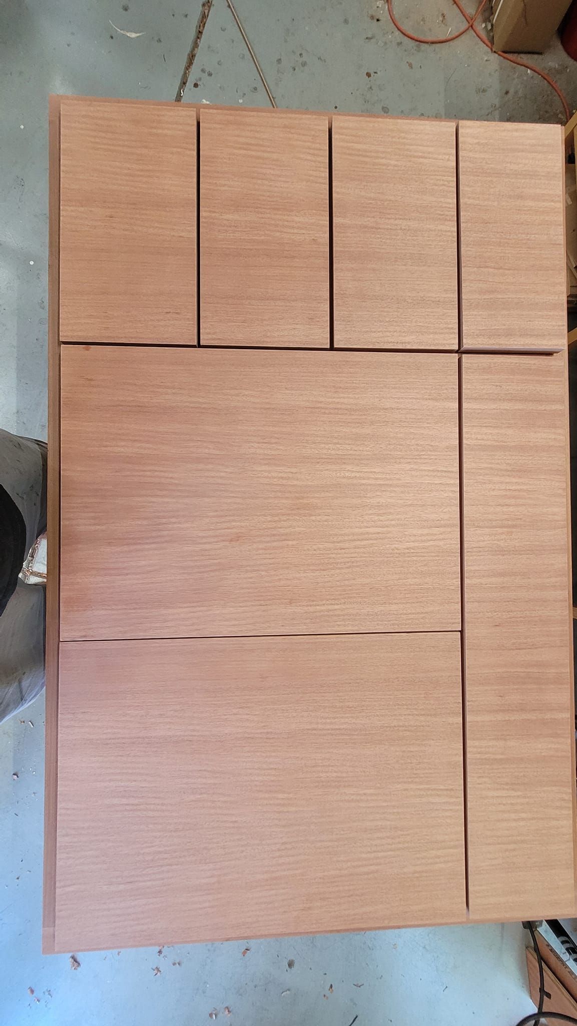 Wooden table top with cutouts for an inset design.