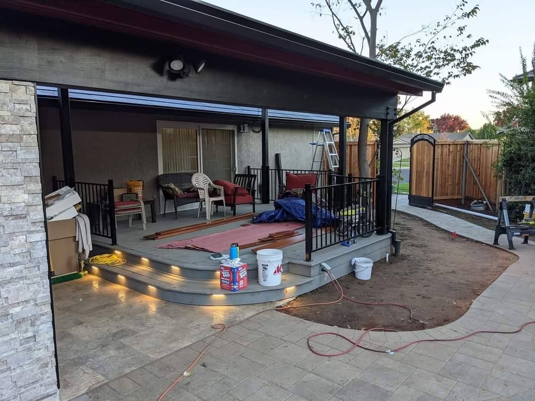 Backyard patio with steps, seating, string lights, and a small garden area.