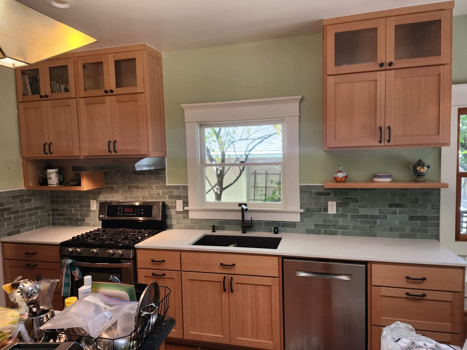 Kitchen with light wood cabinets, white countertops, tile backsplash, and stainless steel appliances.