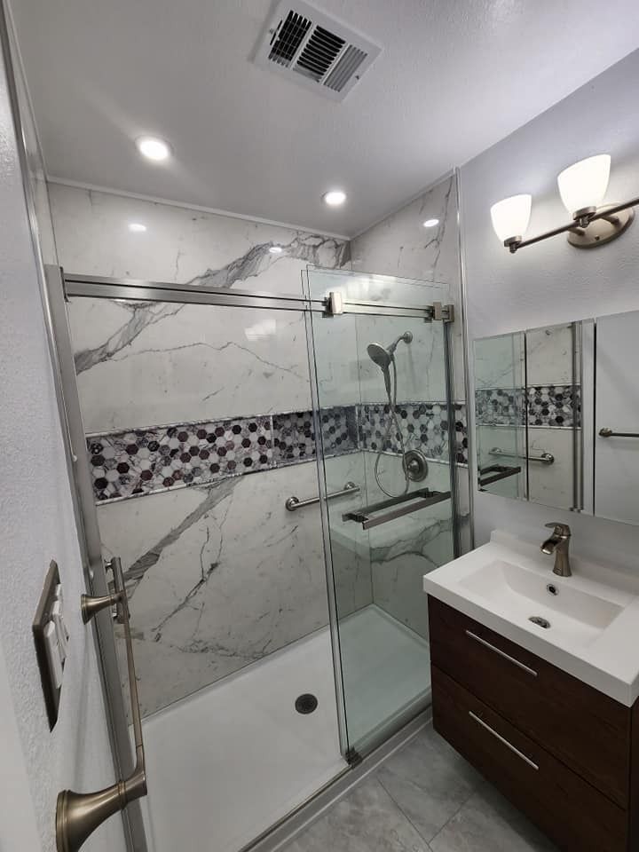 Modern bathroom with marble tile shower and dark wood vanity.