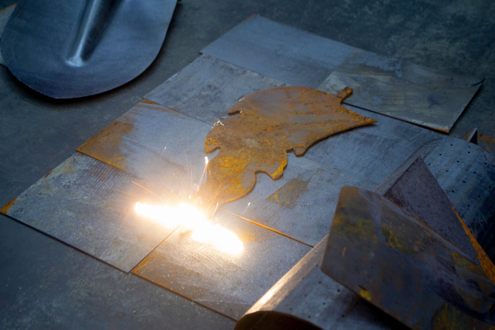 a person is cutting a piece of metal with a torch .