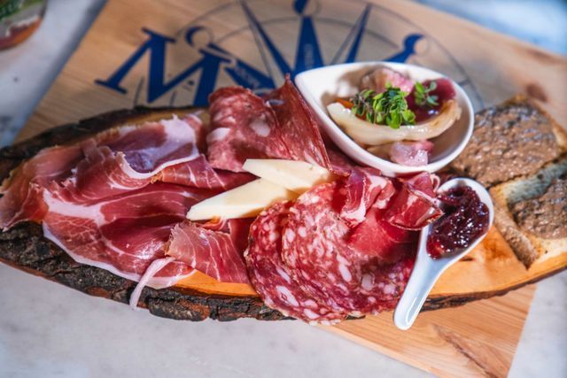 Le mani prendono biscotti e bicchieri di liquido ambrato su un piatto bianco.