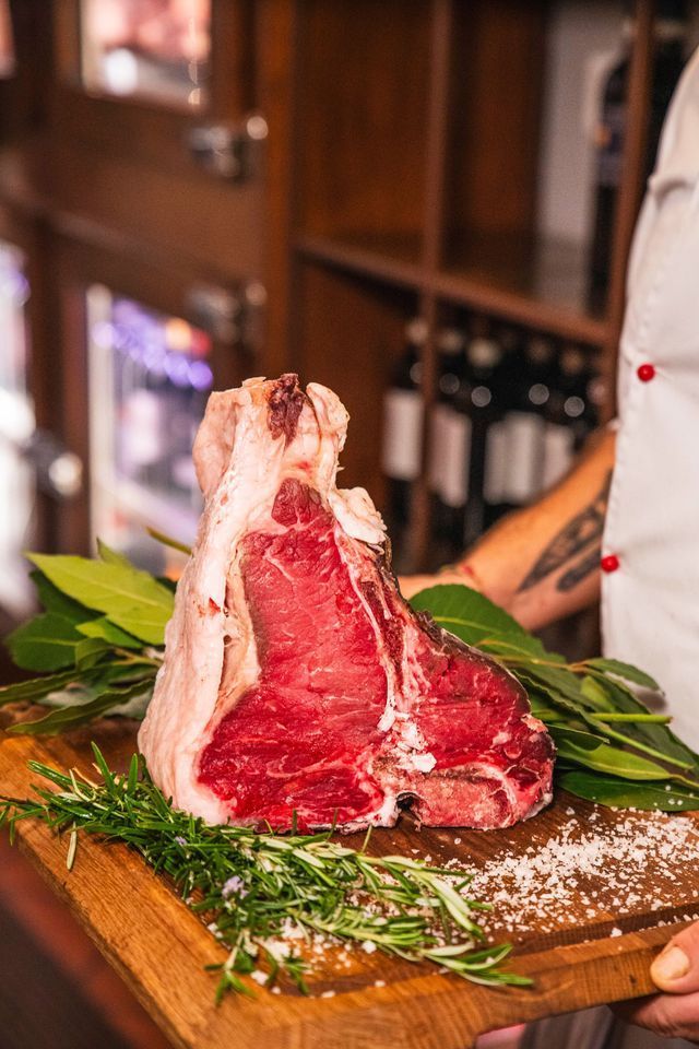 CHEF ADDETTO ALLA GRIGLIA CON MANNAIA IN MANO