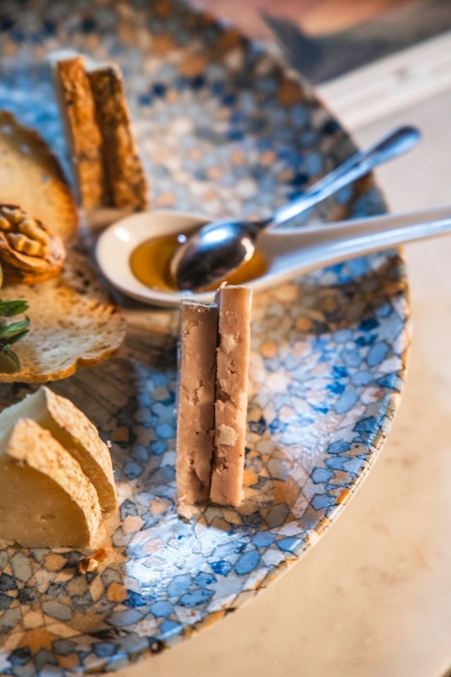 Pasta gialla con gamberi, asparagi e salsa su un piatto bianco.