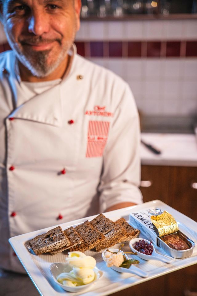 Tagliere di salumi e formaggi; le mani prendono una fetta.