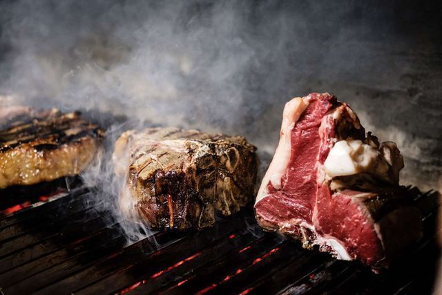 Le mani prendono biscotti e bicchieri di liquido ambrato su un piatto bianco.