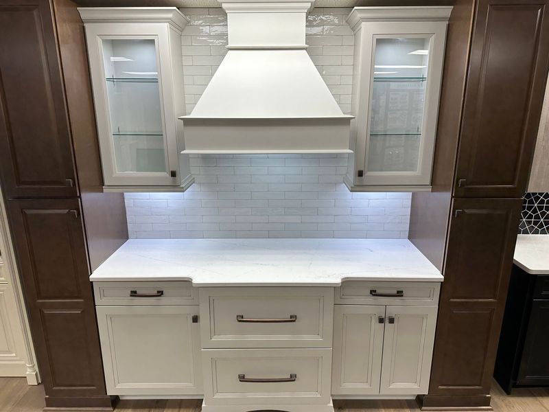 Kitchen with white cabinets, dark brown cabinets, and white countertop.