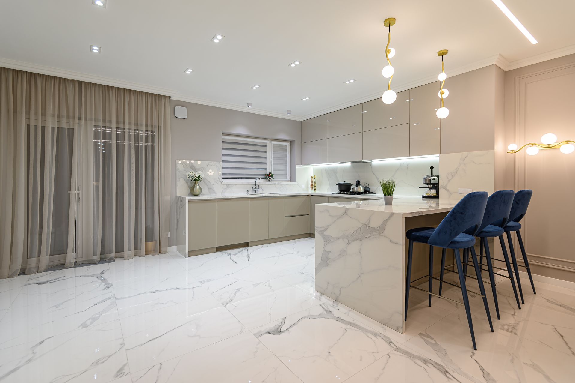 Modern kitchen with marble island and countertops.