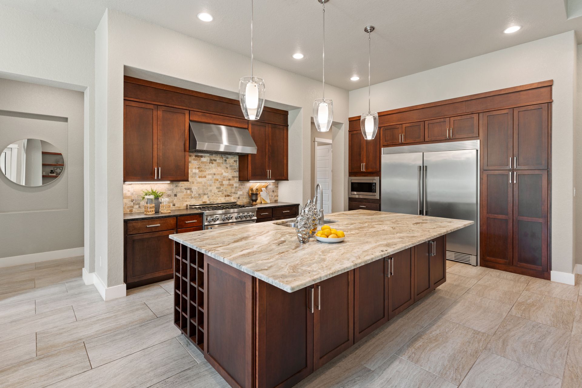 Modern kitchen with brown cabinets, granite countertops, and a large island.