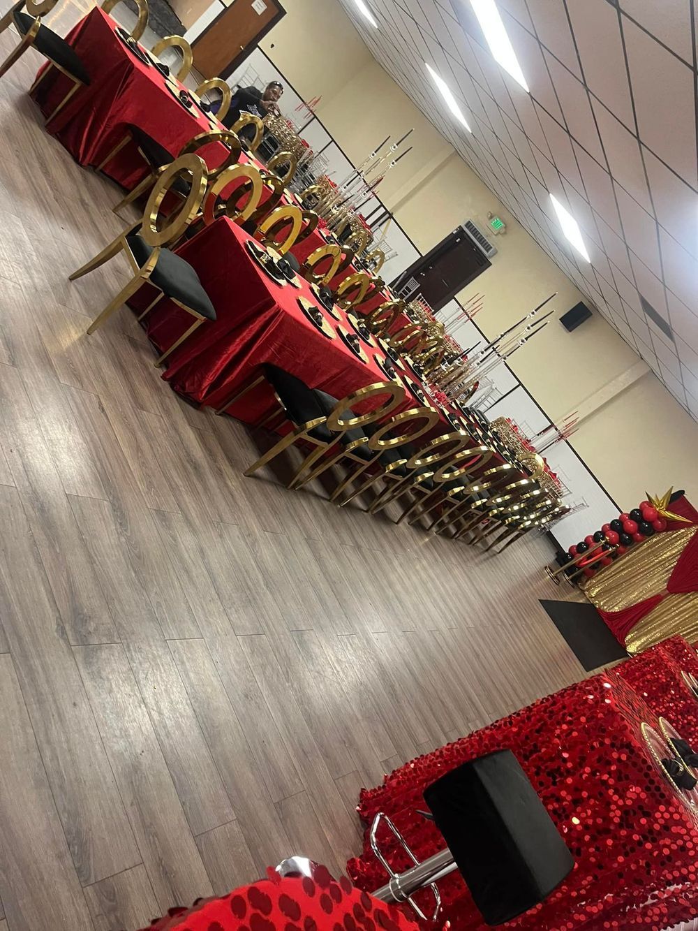 Rows of red-covered tables and gold chairs set in a hall