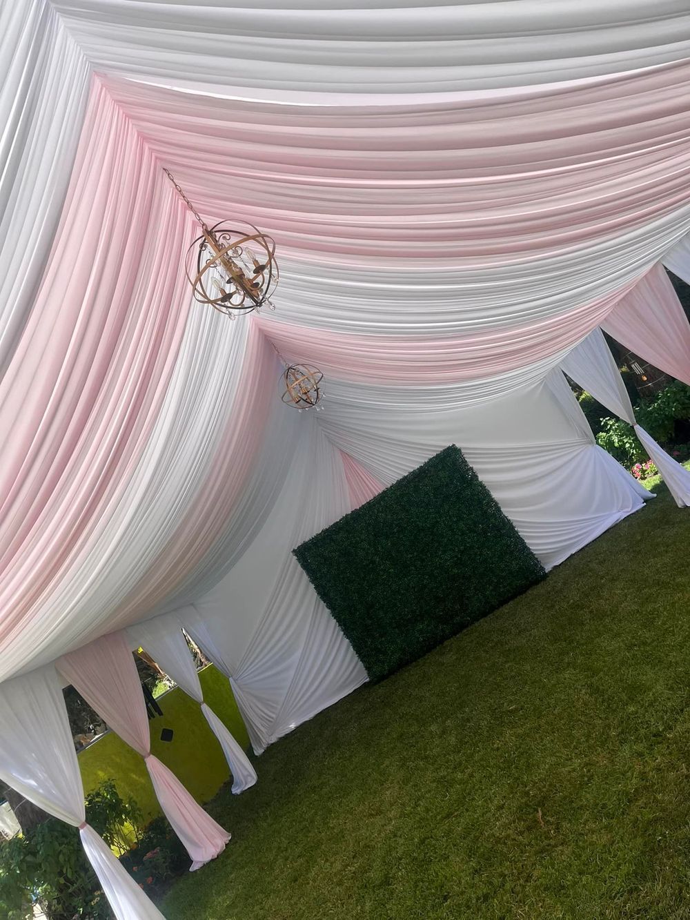 Pink and white draped tent interior with gold light fixtures